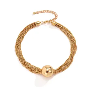 Layered gold chain necklace with smooth cylindrical ball pendant in minimalist style