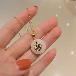 Vue détaillée du collier en jade blanc Ping'an avec pendentif doré Fu et chaîne dorée