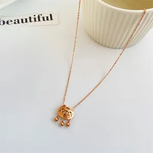 Collana con lucchetto Fu oro rosa e campanellini su sfondo bianco minimalista