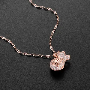 Rose gold money bag necklace with dollar sign and sparkling crystals on black background