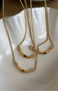 Close-up of three vintage gold-plated necklaces with crescent moon tiger eye stone pendants