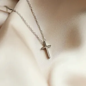 Collier croix argenté minimaliste avec finition polie sur fond de soie élégant