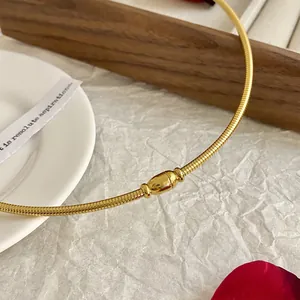 Nahaufnahme der goldenen Röhrenhalskette mit ovalem Verschluss auf Texturhintergrund