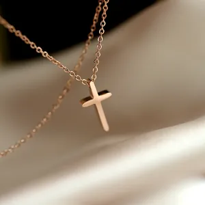Collier pendentif croix en or rose minimaliste sur fond de soie crème pour femme