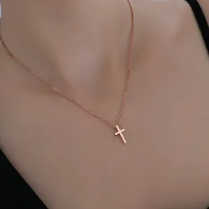 Collier minimaliste avec croix en or rose pour femme porté délicatement sur la clavicule