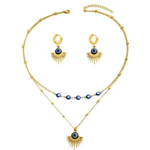 Detail of gold evil eye jewelry set with layered necklace and sunburst earrings