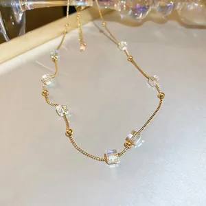 Dettaglio della collana a cubi dorati con perle di cristallo trasparente e catenina