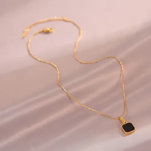 Collier élégant chaîne dorée avec pendentif carré noir sur tissu en soie violet