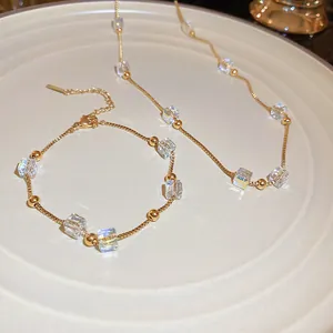 Elegante set collana e bracciale dorati con cristalli quadrati e perle iridescenti