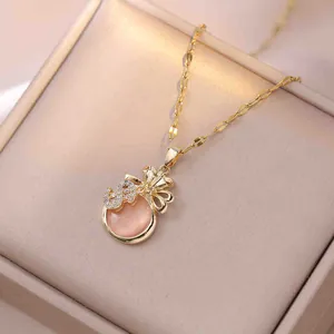 Collier sac de fortune doré avec pierre rose et pendentif signe dollar en cristal