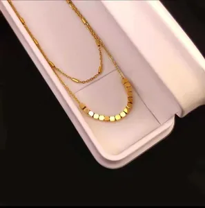Minimalist double layer gold beaded necklace for women displayed on a jewelry box