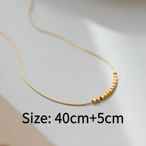 Detail of a minimalist gold layered necklace with small square bead accents, length 40cm+5cm