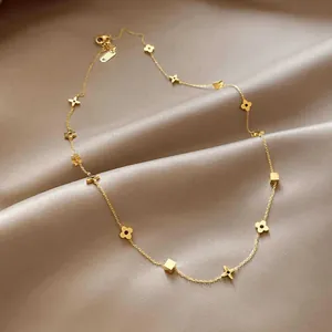 Elegant gold clover titanium steel necklace with square charms on silk background