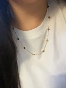 Detail of gold four-leaf clover and star charms on an elegant necklace for women