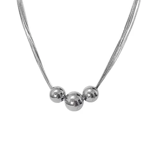 Modern silver multi-strand necklace with three polished spheres on a white background