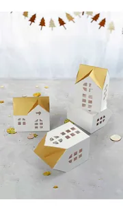 Detail of laser-cut window patterns on white and gold house-shaped favor boxes
