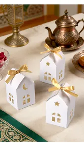 Detail view of house-shaped gift boxes with star and moon cutouts and golden ribbons