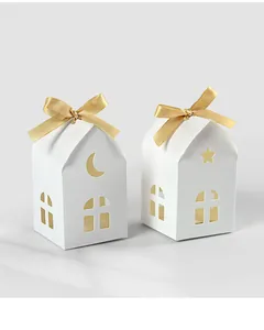 Detailed close-up of white house-shaped gift boxes with moon and star hollow patterns