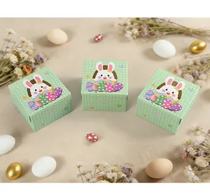 Overhead view of square Easter bunny gift boxes with green polka dots and festive eggs
