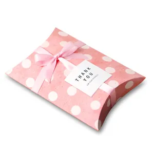 Macro shot of pink polka dot pillow box with silk ribbon and thank you card detail