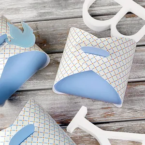 Close-up of light blue pillow gift box with grid pattern and decorative bird tag detail