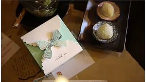 Détail d'une boîte cadeau carrée bleue et blanche avec nœud et texte Thank You