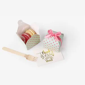Detail view of small green folding gift boxes for candles or soaps with pink ribbons