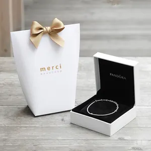 Bracelet à billes en argent avec boîte cadeau élégante et sac à nœud sur bois