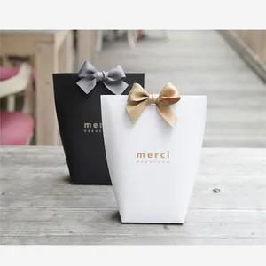 Elegant black and white gift boxes with satin bows and gold Merci Beaucoup printing