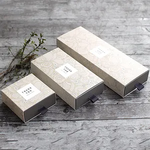 Tre scatole regalo quadrate a cassetto con motivi paisley e etichette Thank You