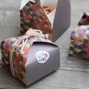 Mini geometric pattern gift box with twine and ribbon ties on vintage wood background