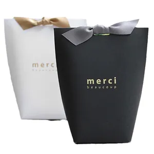 Premium black and white gift boxes with gold foil merci text and satin bow ribbons