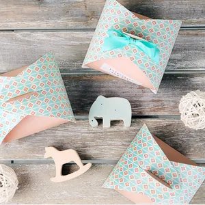 Close-up of creative envelope gift boxes with geometric patterns and mint green ribbons