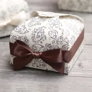 Close-up of vintage square cake gift box with paisley pattern and brown satin bow