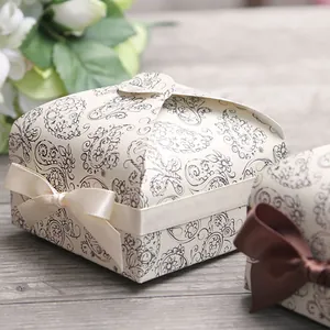 Macro detail of vintage paisley gift box with elegant cream satin ribbon and bow