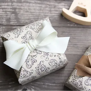 Detail of purple paisley gift box with white satin ribbon on vintage wood background