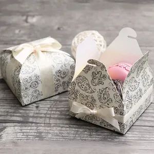 Close-up of a mini vintage square gift box with paisley patterns and a satin ribbon bow