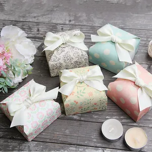 Set of floral paper gift boxes with silk bows on vintage dark wood background