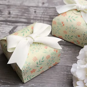 Mini floral square gift box with elegant white ribbon bow on vintage wood surface