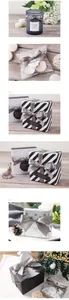 Detailed view of grey satin ribbon tied in a bow on a striped gift box with a thank you tag