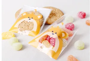 Detalle de bolsas para snacks con diseño de hámster y ventana para galletas y caramelos