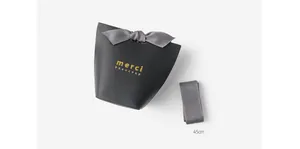 Detail of black gift box with gold merci beaucoup foil and 45cm grey satin ribbon bow