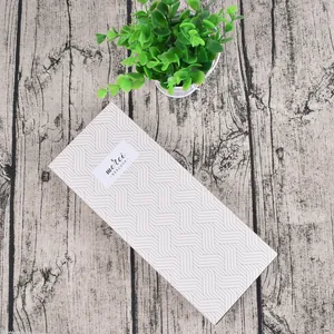 Detail of white drawer gift box with grey woven pattern and merci beaucoup label