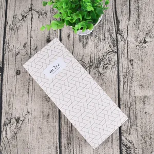 Detail view of drawer-style gift box with geometric patterns and Merci Beaucoup label
