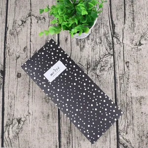 Detail view of black drawer gift box with white polka dots and merci beaucoup label