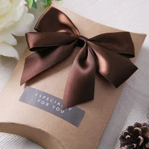 Macro di un fiocco di raso marrone su una scatola regalo in carta kraft marrone