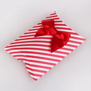 Red and white striped pillow gift box with a glossy large red satin ribbon bow