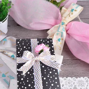 Détail de rubans en satin avec imprimé Love et motif chevron sur boîte cadeau