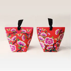 Detail of red floral gift box with peony pattern and black satin ribbon closure