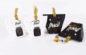 Détail de petites boîtes cadeaux élégantes avec motifs d'étoiles dorées et texte Merci